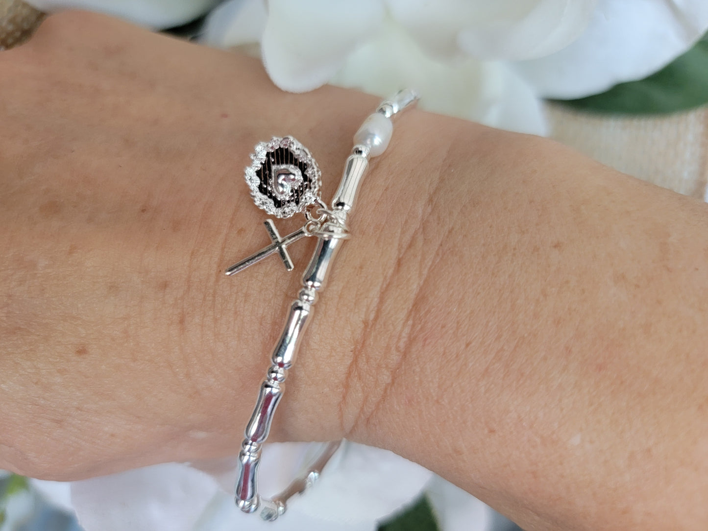 Sterling silver bracelet with a pearl and 2 charms